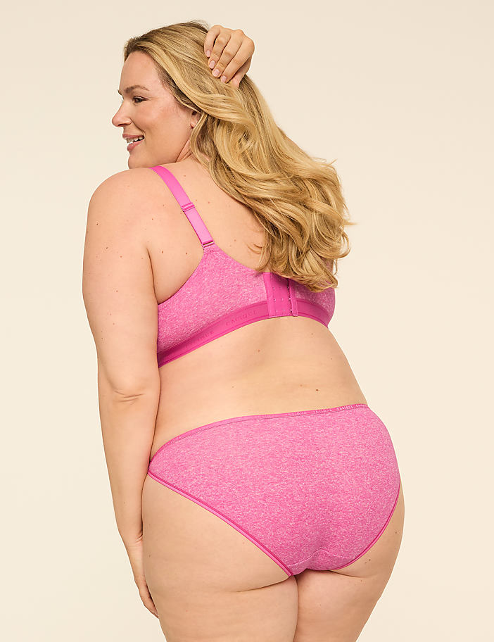 A woman in a pink bra and panties stands with her back to the camera against a plain, light-colored background.