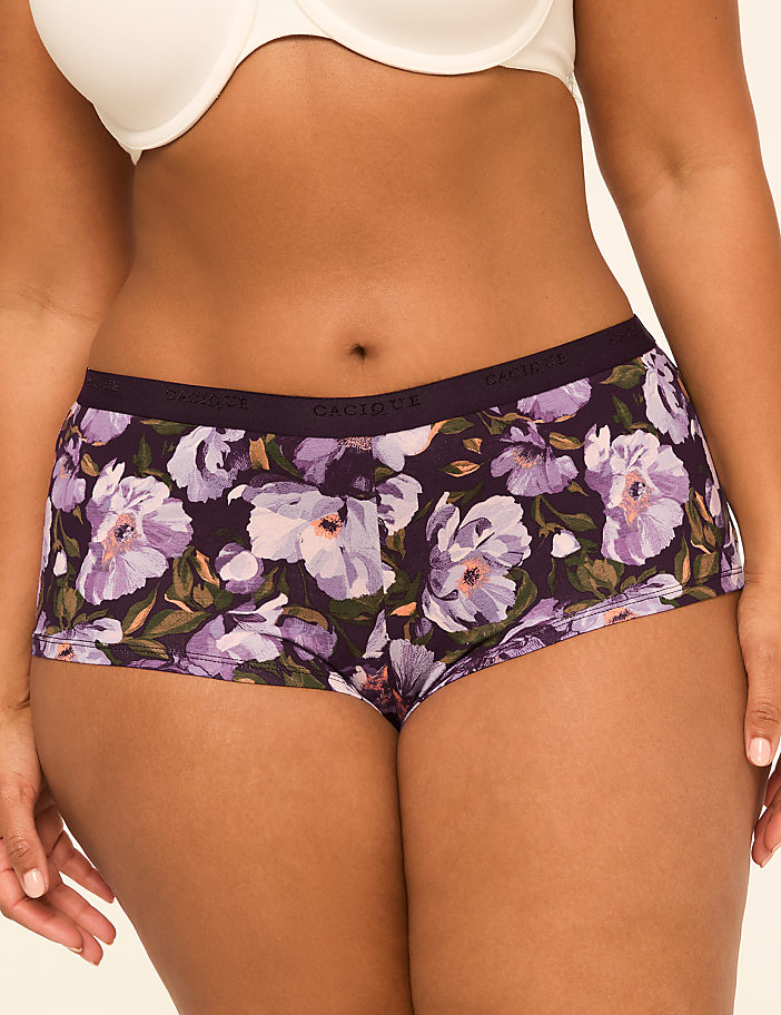 A person wears floral-patterned underwear in the foreground, with a plain white bra visible above.