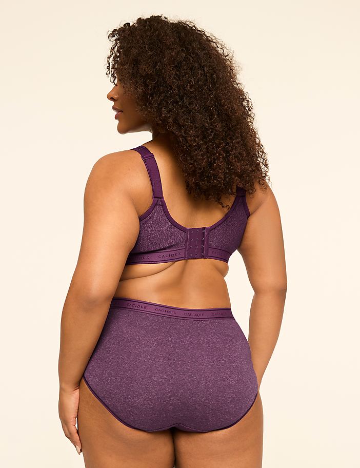 A woman in a purple bra and matching underwear stands with her back to the viewer against a plain, light background.