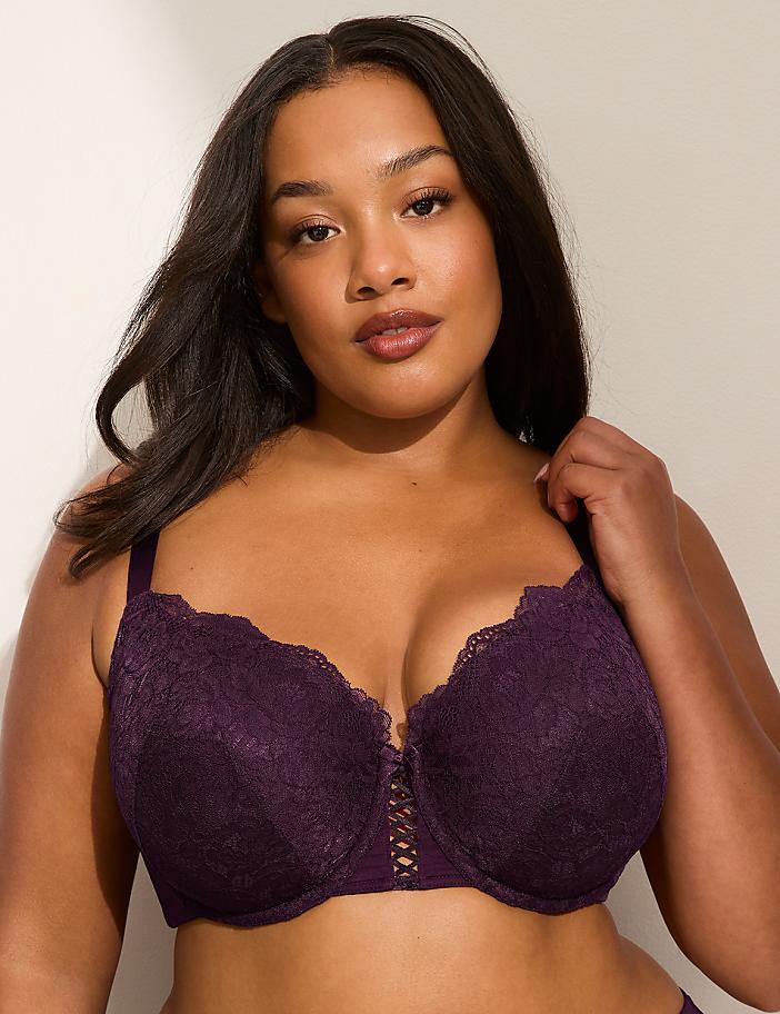 A woman with dark hair and a purple lace bra is posed against a plain, light-colored background.