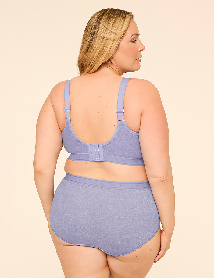 A woman in a light purple bra and underwear stands facing away from the camera against a plain, light-colored background.