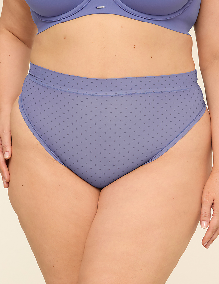 A person's lower torso is shown wearing a blue polka dot high-waisted brief and a matching bra, against a plain background.