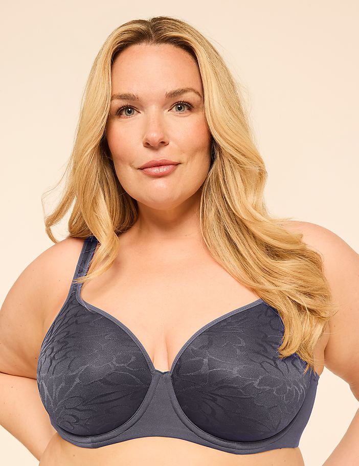 A woman with blonde hair and a blue bra is centered against a plain, light-colored background.