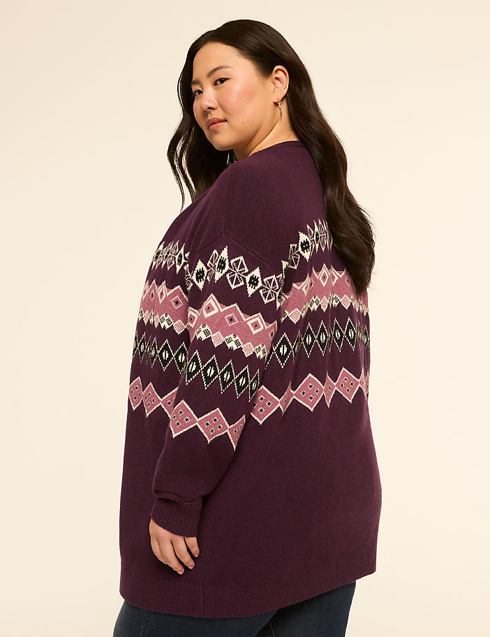 A woman in a purple Fair Isle sweater stands against a plain, light-colored background.