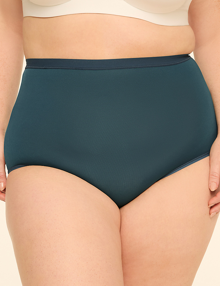 A person's torso is shown from the waist down, wearing teal high-waisted underwear and a white bra, against a plain background.