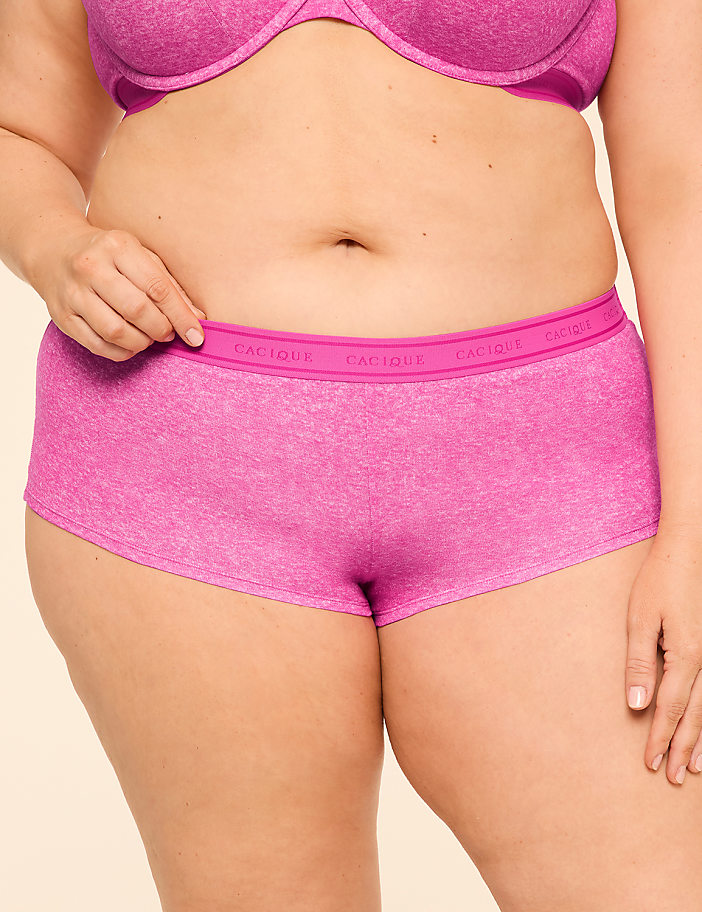 A person in pink underwear stands against a plain background.
