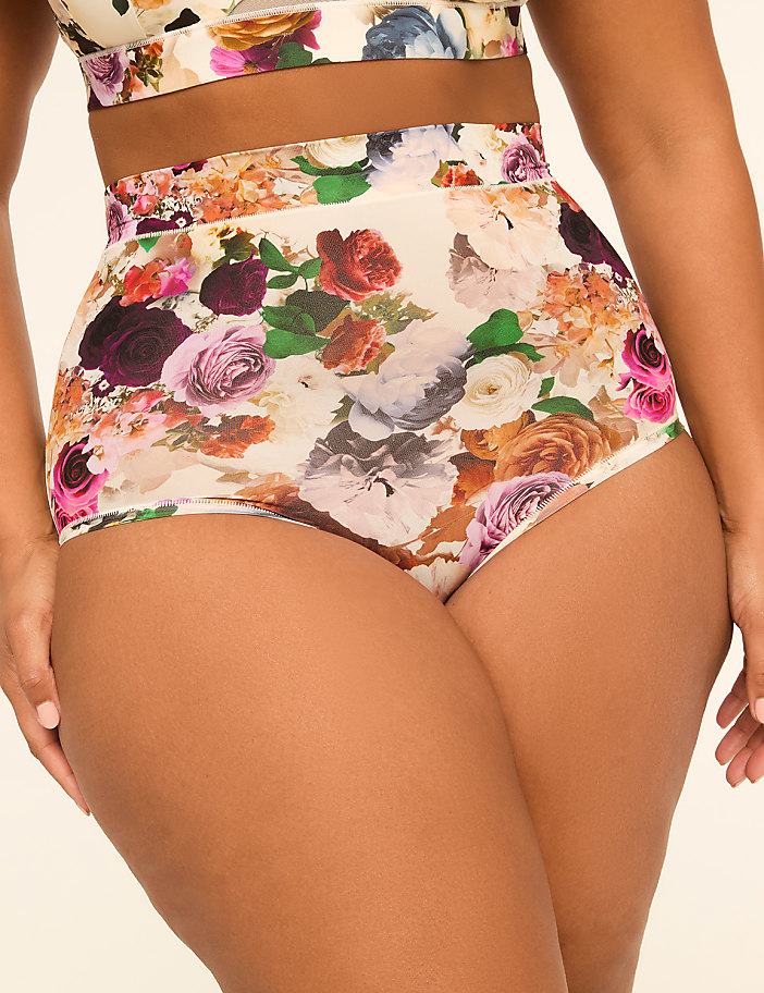 A person wears high-waisted floral print underwear and a matching bra against a plain, light background.