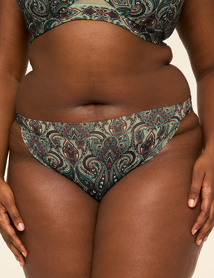 A person's midsection is shown in the foreground, wearing patterned underwear, against a plain background.