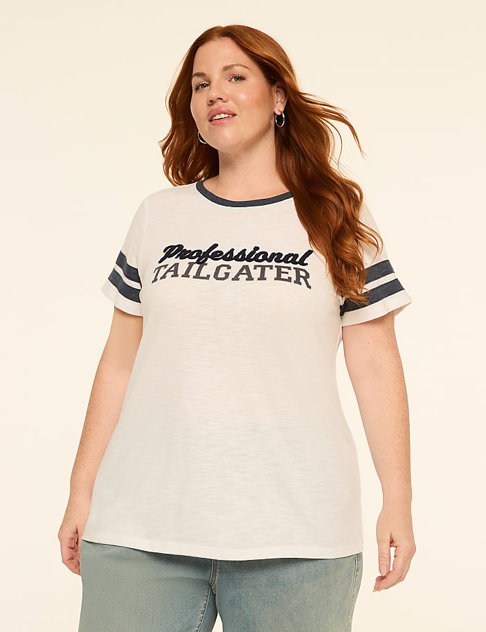 A woman with red hair and a white t-shirt that says "Professional Tailgater" stands against a plain, light-colored background.