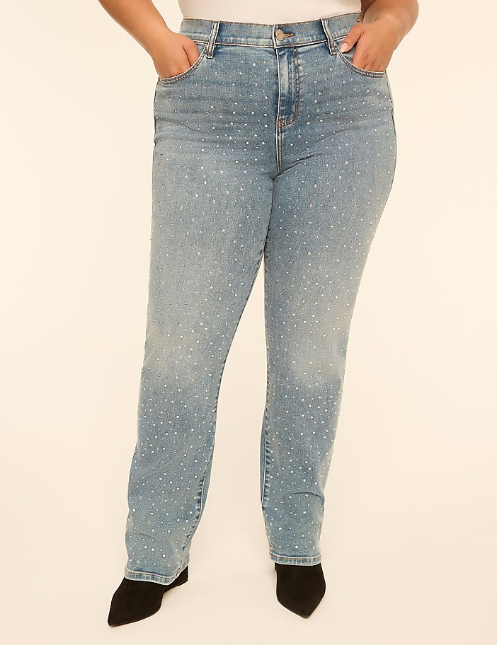 A person wearing light-wash denim jeans with scattered rhinestones stands against a plain, light-colored background.