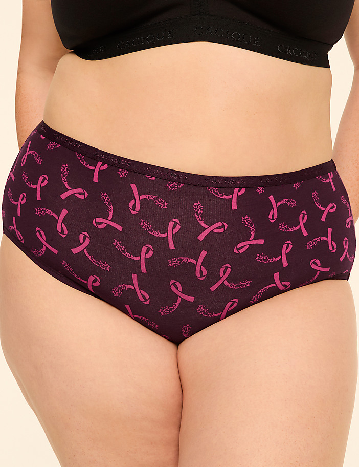 A person is wearing dark purple underwear with a pattern of pink ribbons and leaves, against a plain, light-colored background.