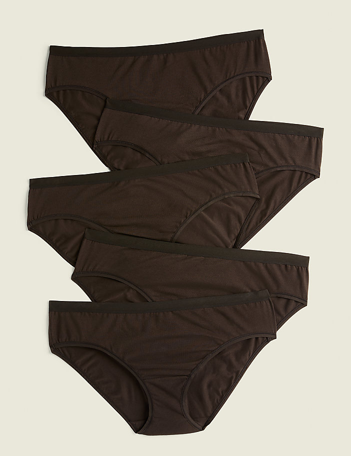 Five brown cotton briefs are neatly stacked on a light beige background.