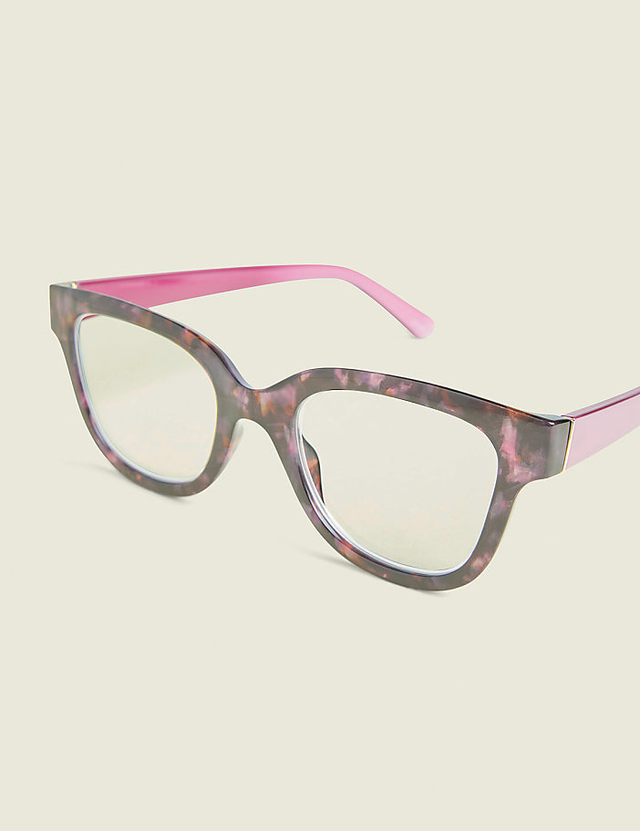 A pair of tortoiseshell glasses with pink temples rests on a plain, light-colored background.