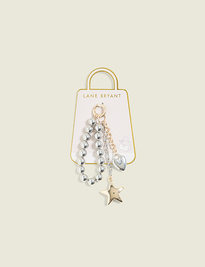 A beaded bracelet with a heart and star charm hangs from a Lane Bryant tag against a pale yellow background.