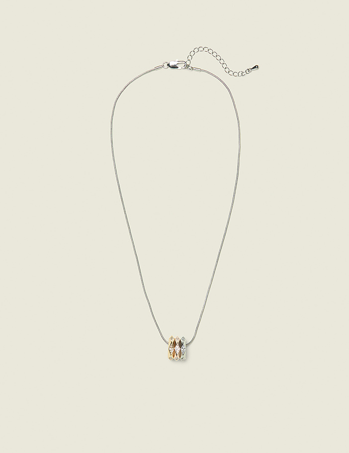 A delicate silver necklace with a cluster of sparkling gemstones hangs against a plain, light-colored background.