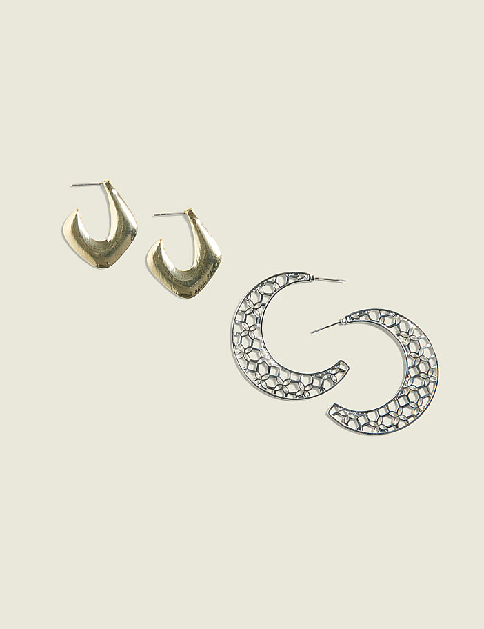 Two pairs of earrings, one gold and angular, the other silver and circular with a honeycomb pattern, are displayed against a pale green background.