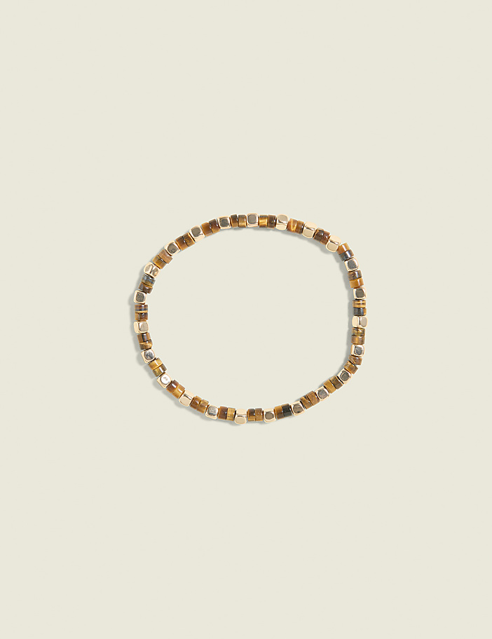 A beaded bracelet with tiger's eye and metallic beads rests on a pale beige background.