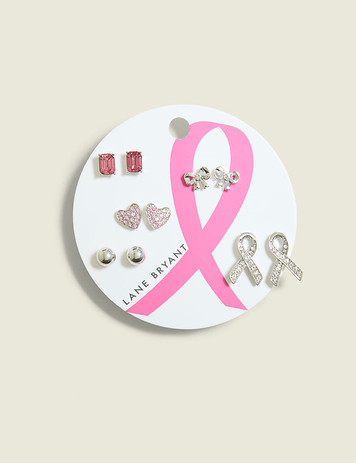 A set of six pairs of earrings, including pink hearts, silver studs, and crystal ribbons, are displayed on a white card with a pink breast cancer awareness ribbon against a light gray background.