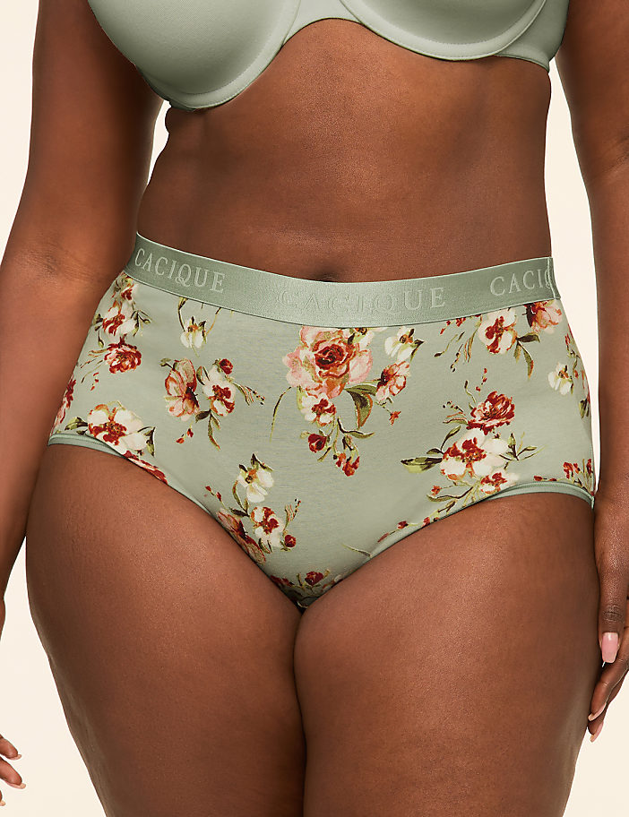 A woman in floral patterned underwear stands against a plain, light-colored background.