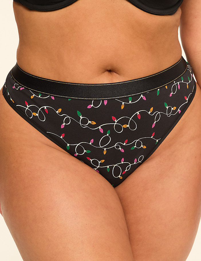 A pair of black underwear with a festive string of colorful Christmas lights pattern is shown against a plain, light-colored background.