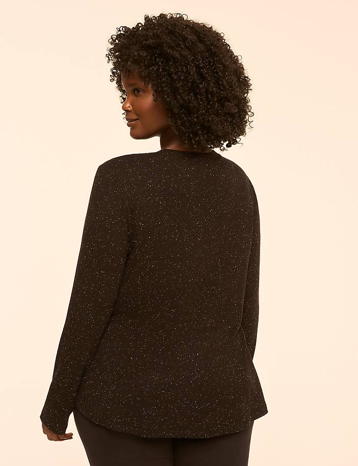 A woman with curly dark hair is shown from the back, wearing a black sparkly long-sleeved shirt against a plain, light-colored background.