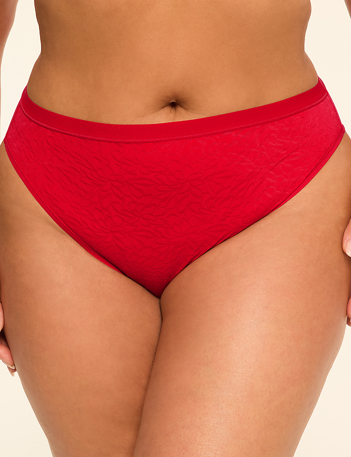 A close-up of a person wearing red underwear fills the foreground, with a plain, light-colored background.
