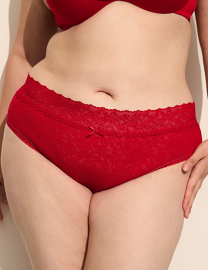 A person's midsection is shown in the foreground, wearing red lace underwear and a matching bra, against a plain, light-colored background.