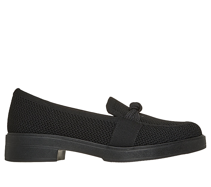 A black knit loafer with a decorative knot sits on a white background.