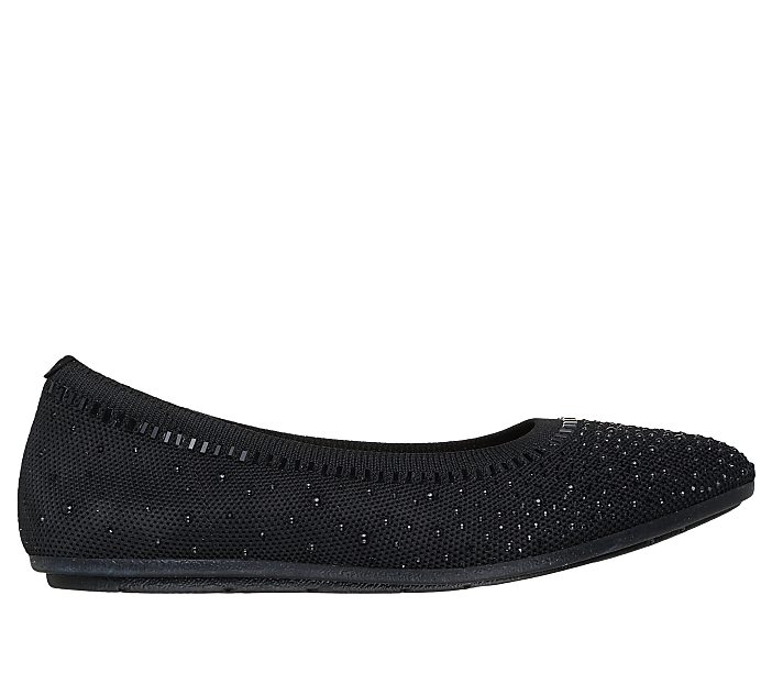 A black, sparkly ballet flat rests on a plain white background.