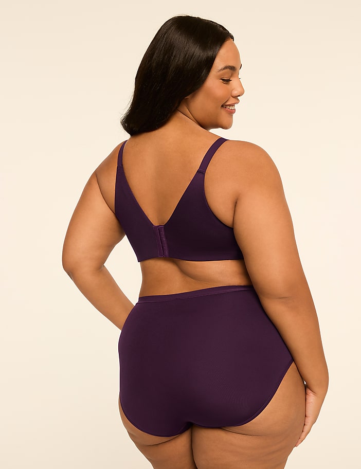 A woman in a purple bra and underwear is shown from the back against a plain, light-colored background.