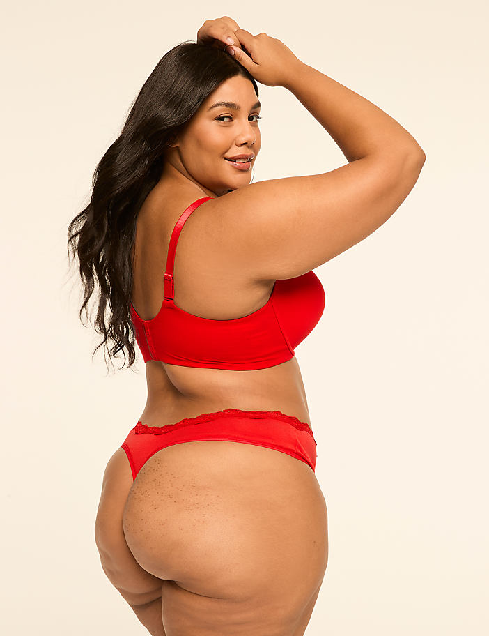 A woman in red lingerie poses against a plain, light background.