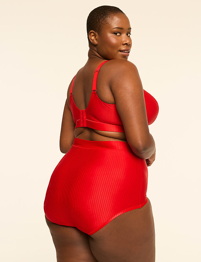 A woman in a red ribbed bikini poses against a plain, light-colored background.
