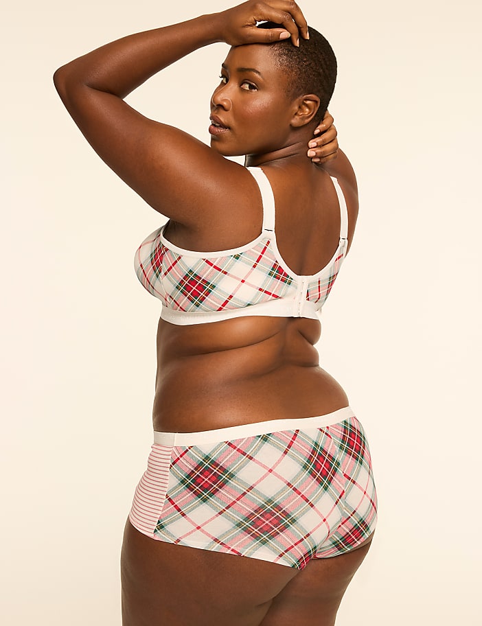 A woman in a plaid bra and shorts poses against a plain, light-colored background.