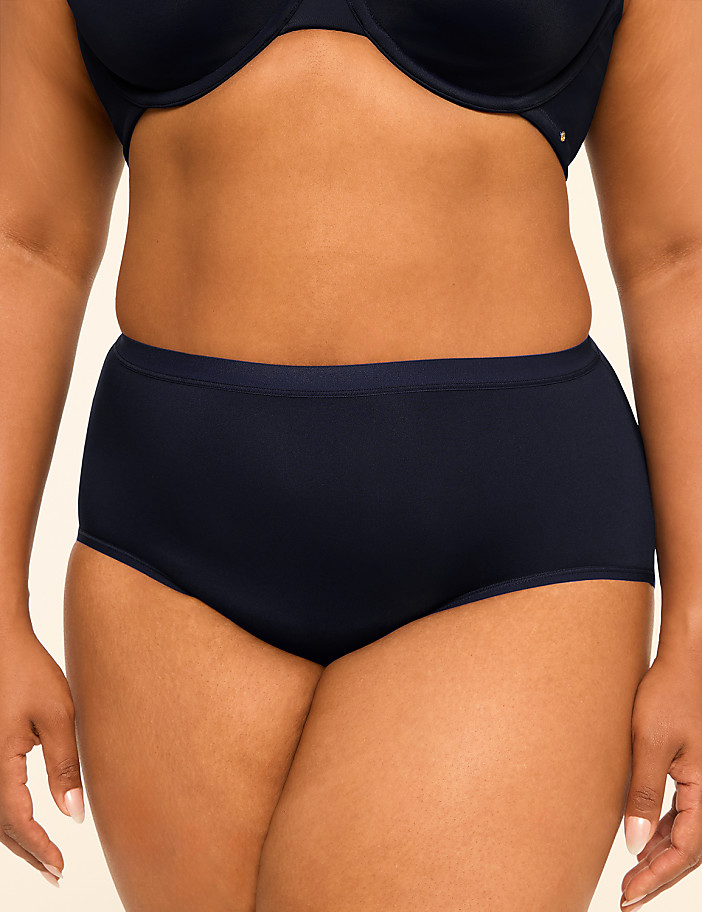 A woman's torso is shown from the waist down, wearing dark blue high-waisted underwear and a matching bra, against a plain, light-colored background.