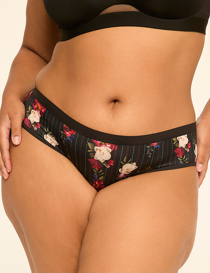 A person's midsection is shown in the foreground, wearing floral-patterned underwear, against a plain, light-colored background.