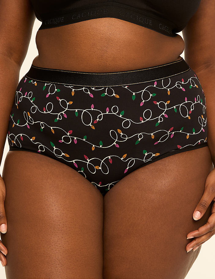 A person wearing black underwear with a string light pattern stands against a plain, light-colored background.