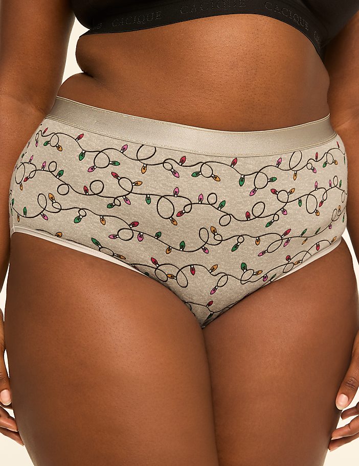 A person wears light grey underwear with a festive string light pattern, against a blurred background.