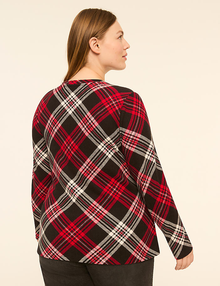A woman in a red, black, and white plaid shirt is shown from the back against a plain, light-colored background.