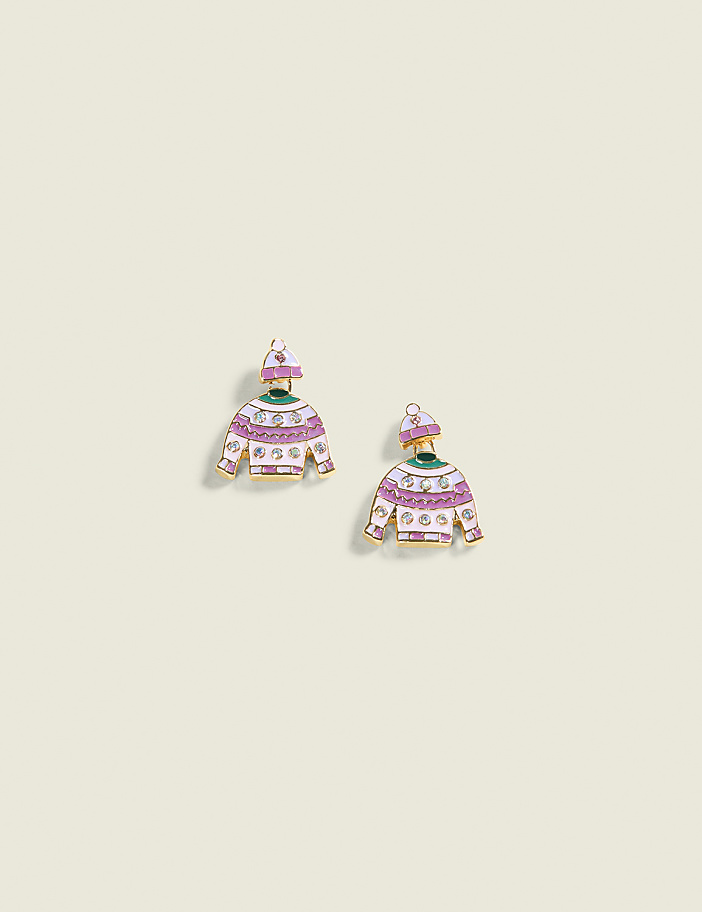 Two whimsical sweater-shaped earrings with purple and white stripes and a green collar are displayed against a plain, light cream background.