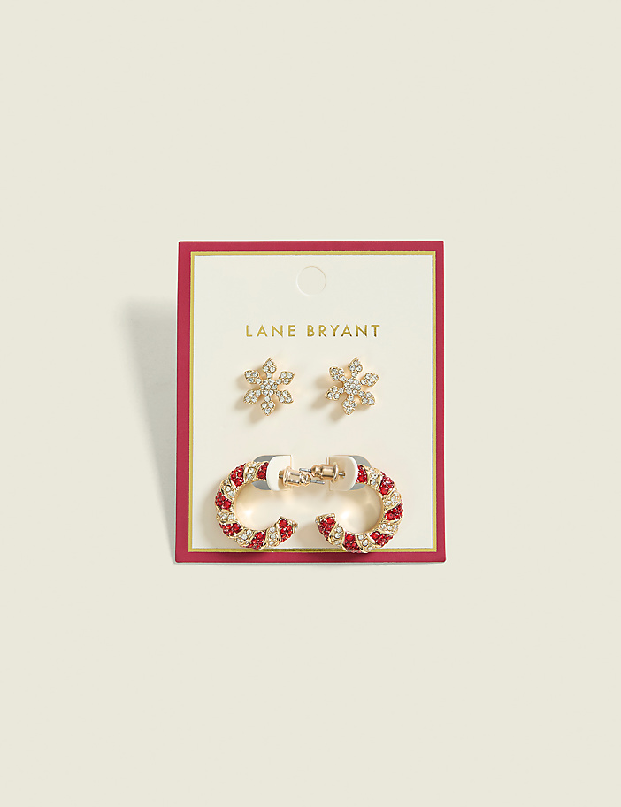 Two pairs of festive holiday earrings, one snowflake-shaped and the other candy cane-striped, are displayed on a pink card against a pale pink background.