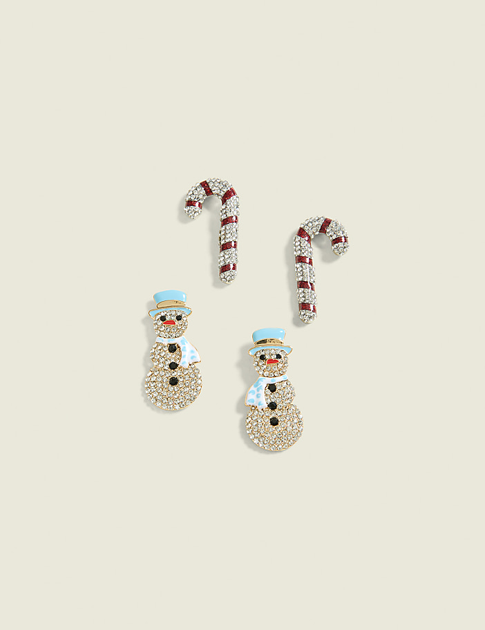 Two sparkly snowman charms and two candy cane charms are arranged on a pale, textured background.