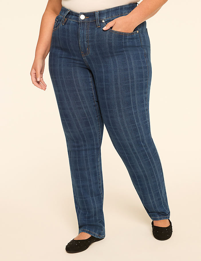 A woman in striped jeans and black flats stands against a plain, light-colored background.