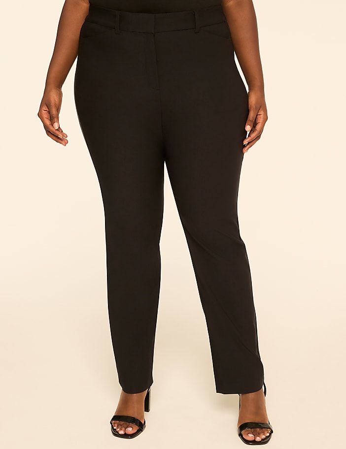 A person stands in black pants and heels against a plain, light-colored background.