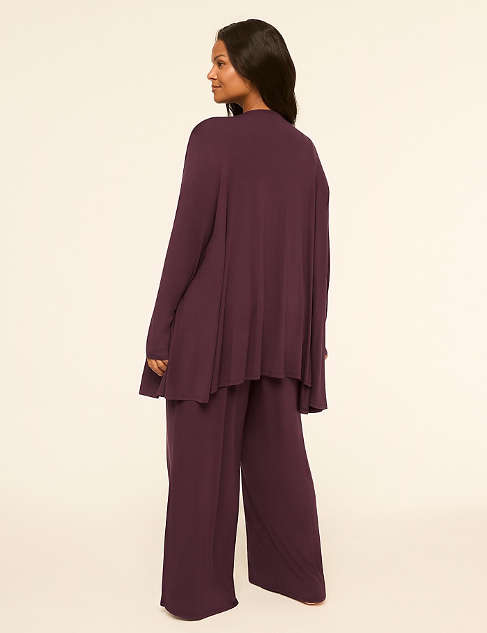 A woman in a plum-colored loungewear set stands against a plain, light-colored background.