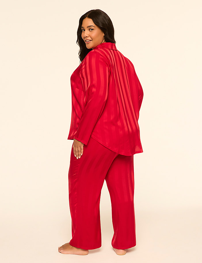 A woman in red striped pajamas stands against a plain, light-colored background.
