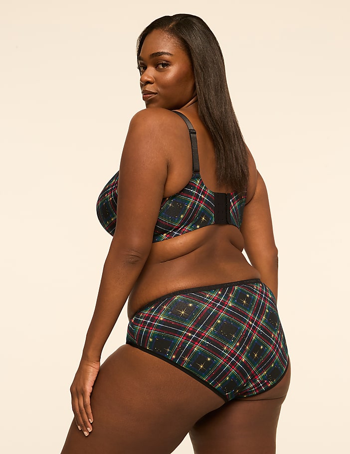A woman in plaid lingerie poses against a plain, light-colored background.
