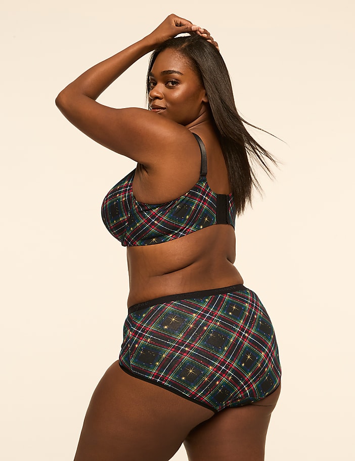 A woman in plaid lingerie poses against a plain, light-colored background.