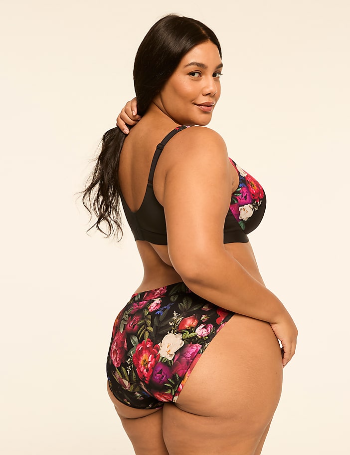 A woman in floral lingerie poses against a plain, light-colored background.