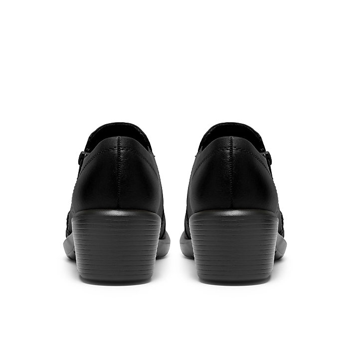 A pair of black leather shoes is positioned in the foreground against a plain white background.