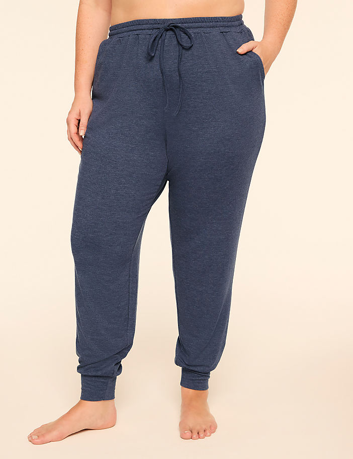 A person wearing navy blue drawstring joggers stands against a plain, light-colored background.